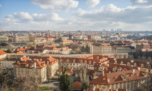 A day time photo of a city with red roof tops and brown brick houses called Prague
